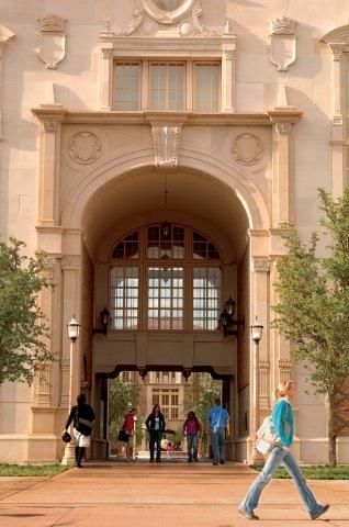 A group of people walking in front of a building