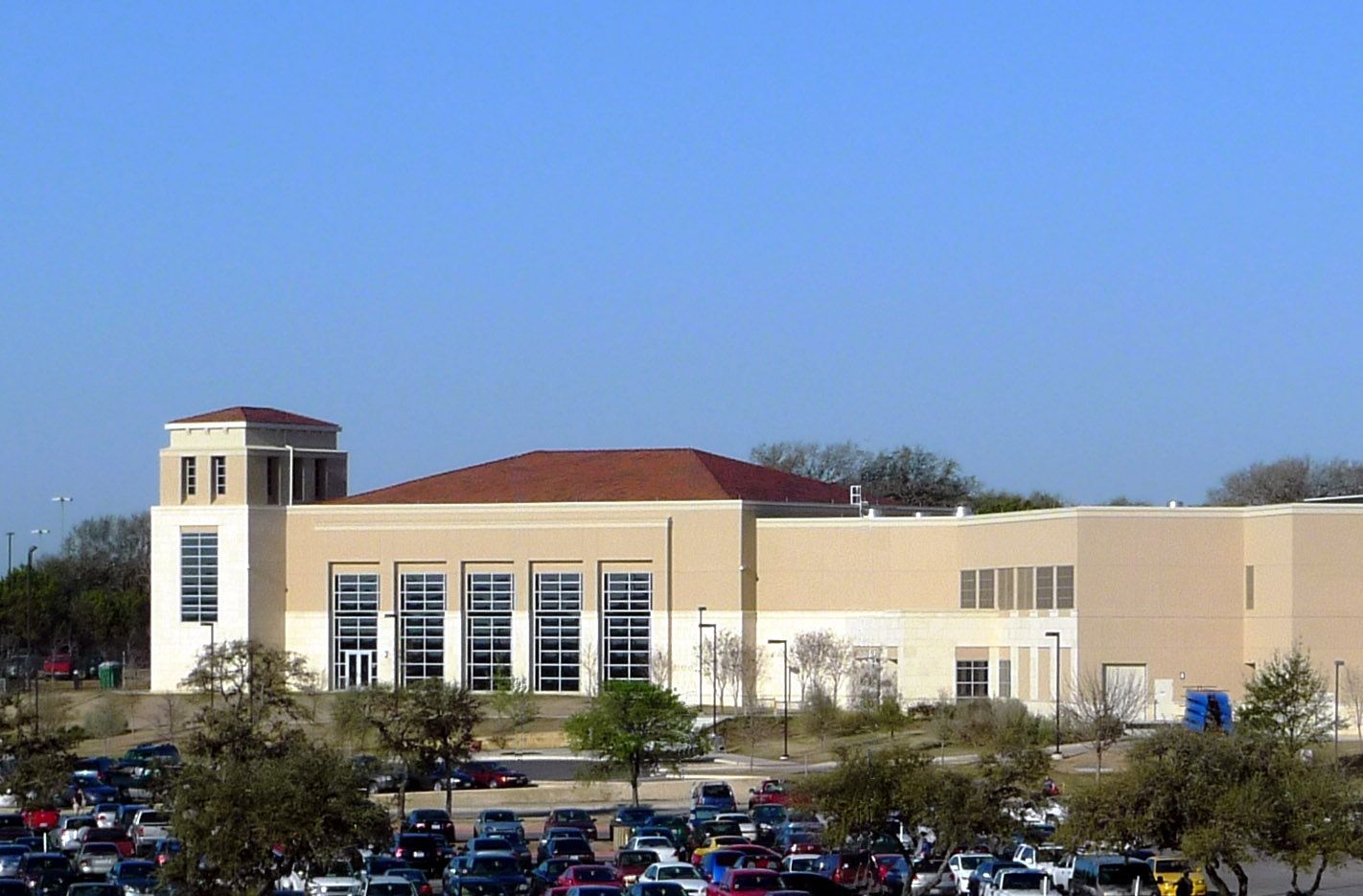 A large building with a lot of cars parked in front of it