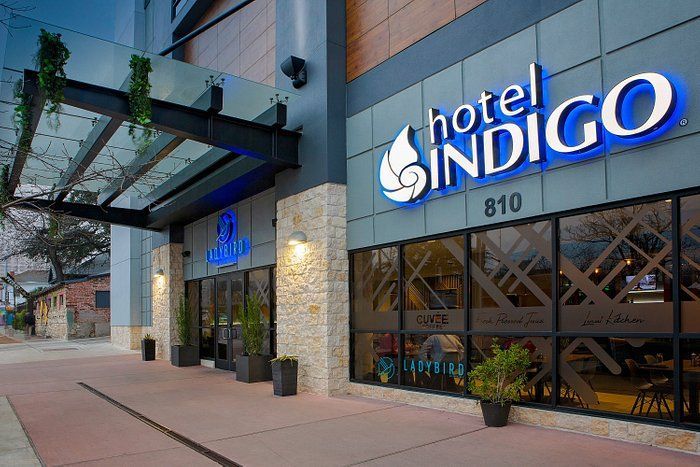 The hotel indigo is located on the corner of a city street.