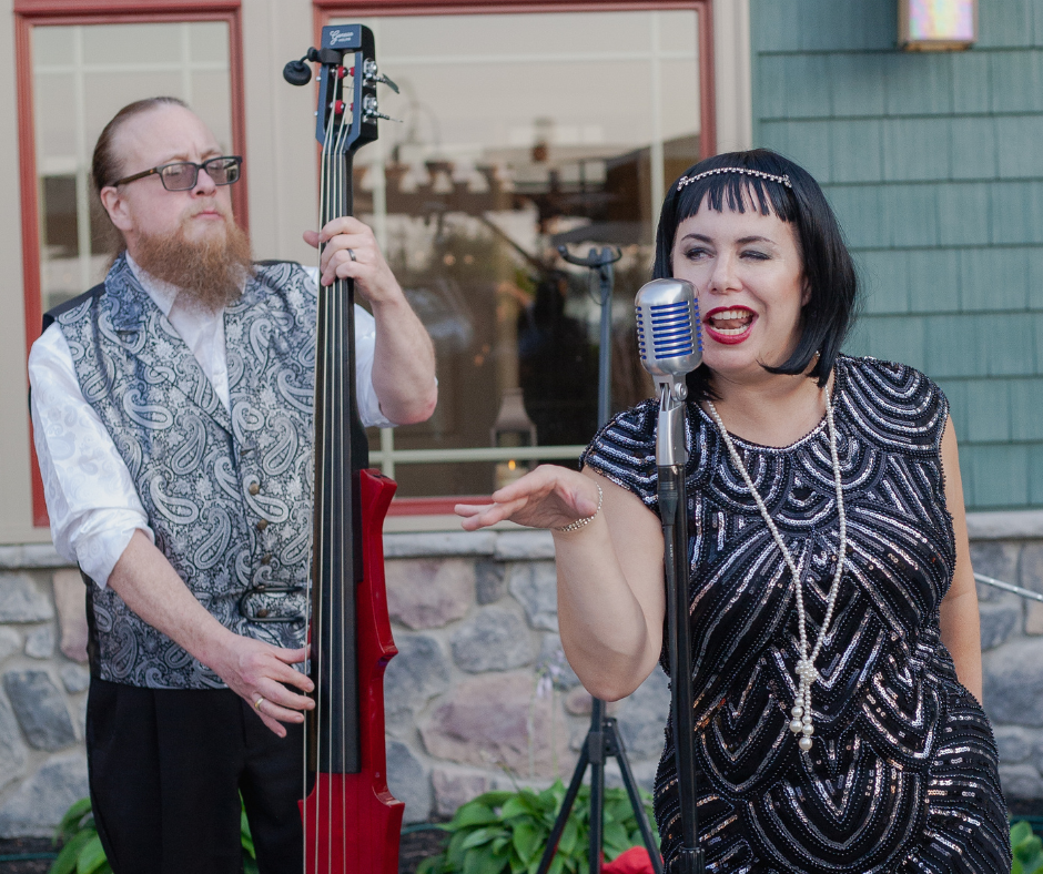 A man playing a double bass and a woman singing into a microphone
