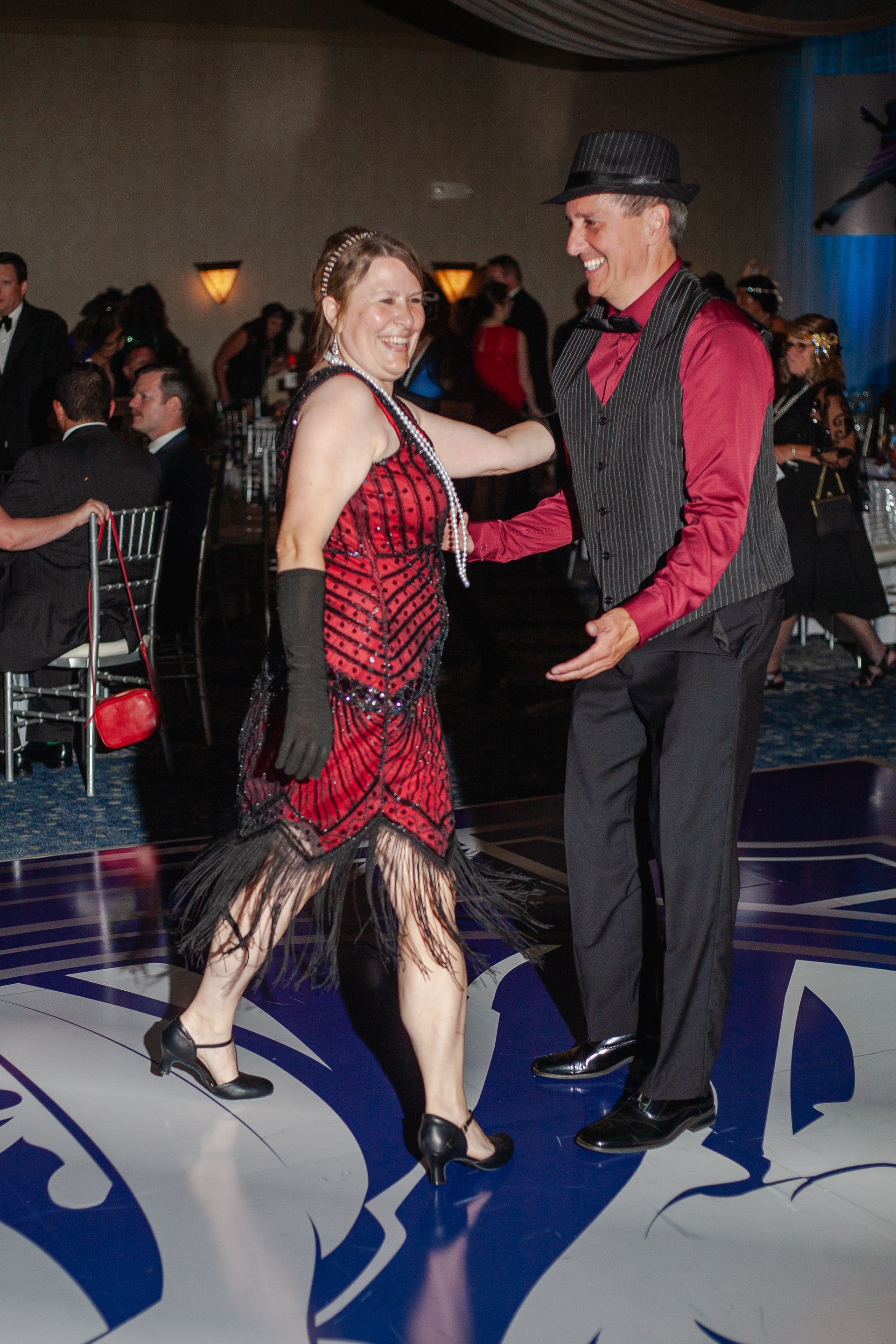 A man and a woman are dancing on a dance floor