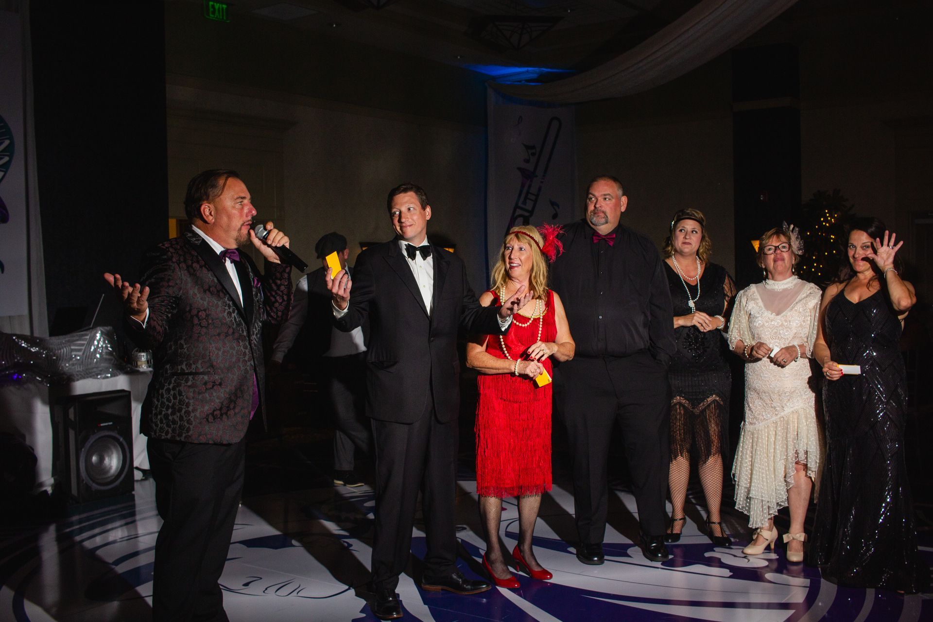 A group of people are standing on a stage holding microphones.