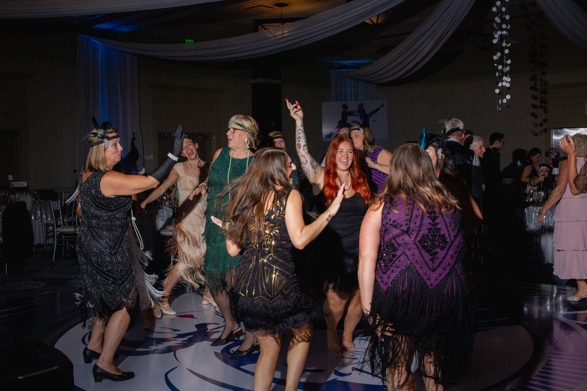 A group of women are dancing on a dance floor at a party.