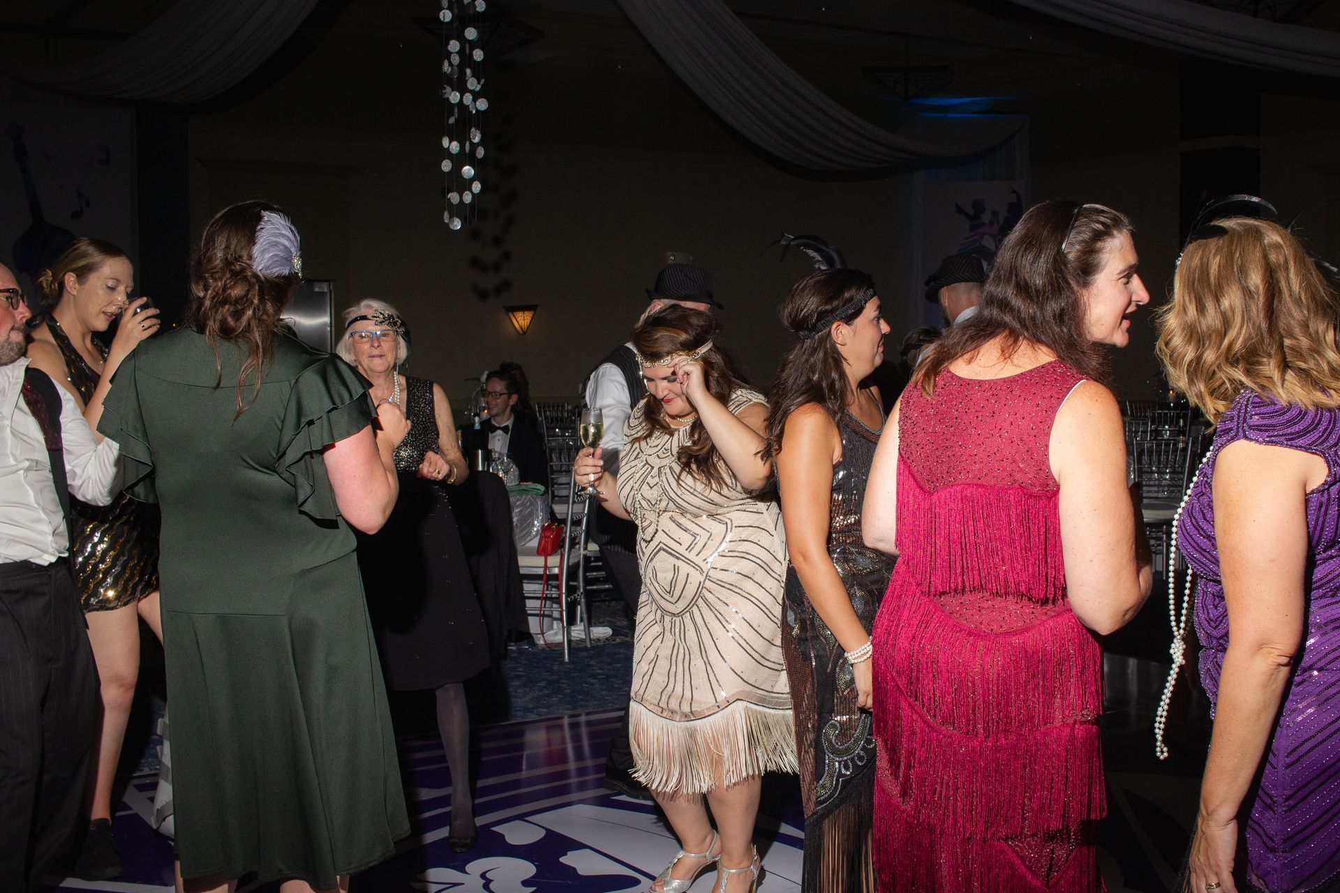 A group of women are dancing on a dance floor at a party.