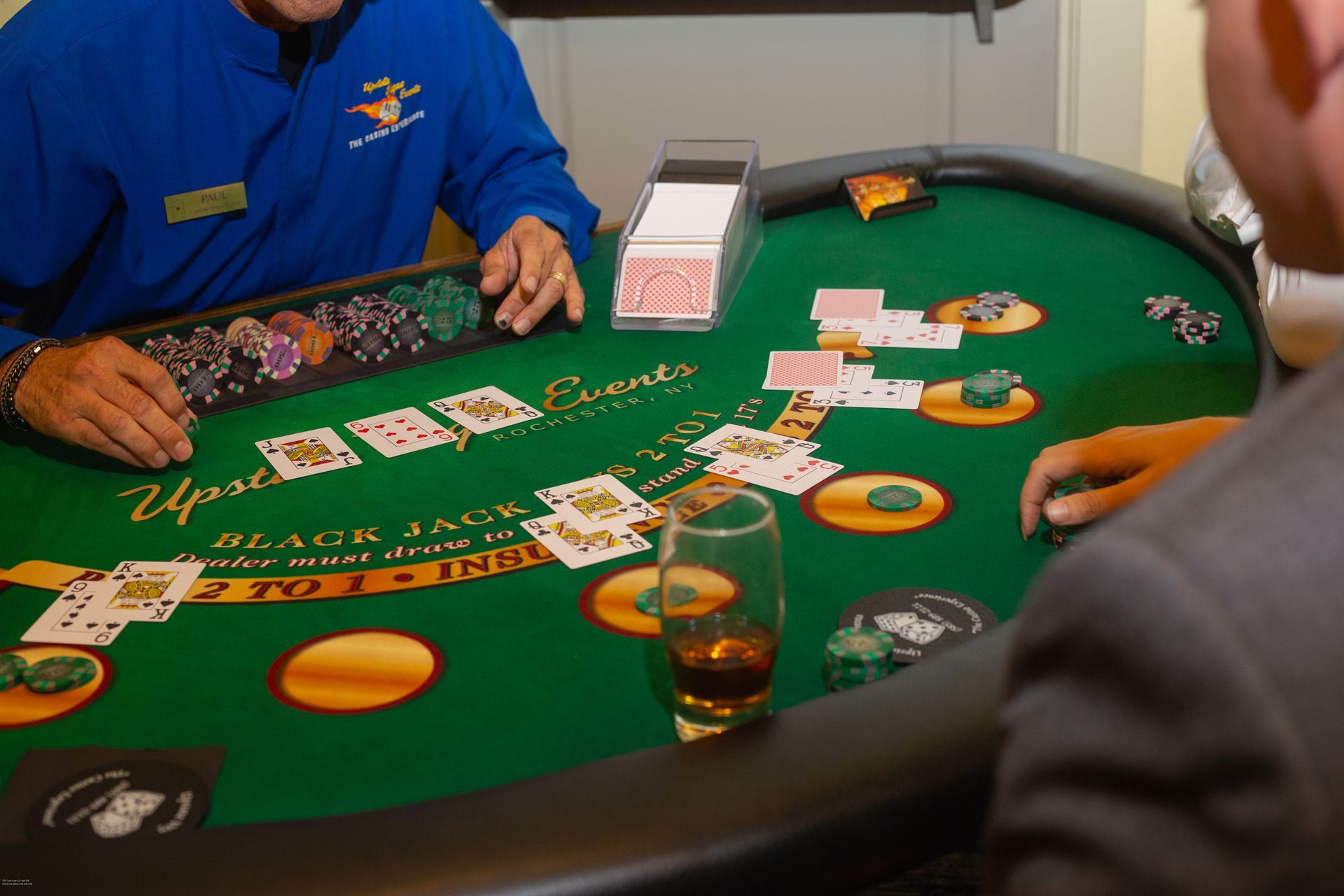 A man in a blue jacket is playing a game of blackjack