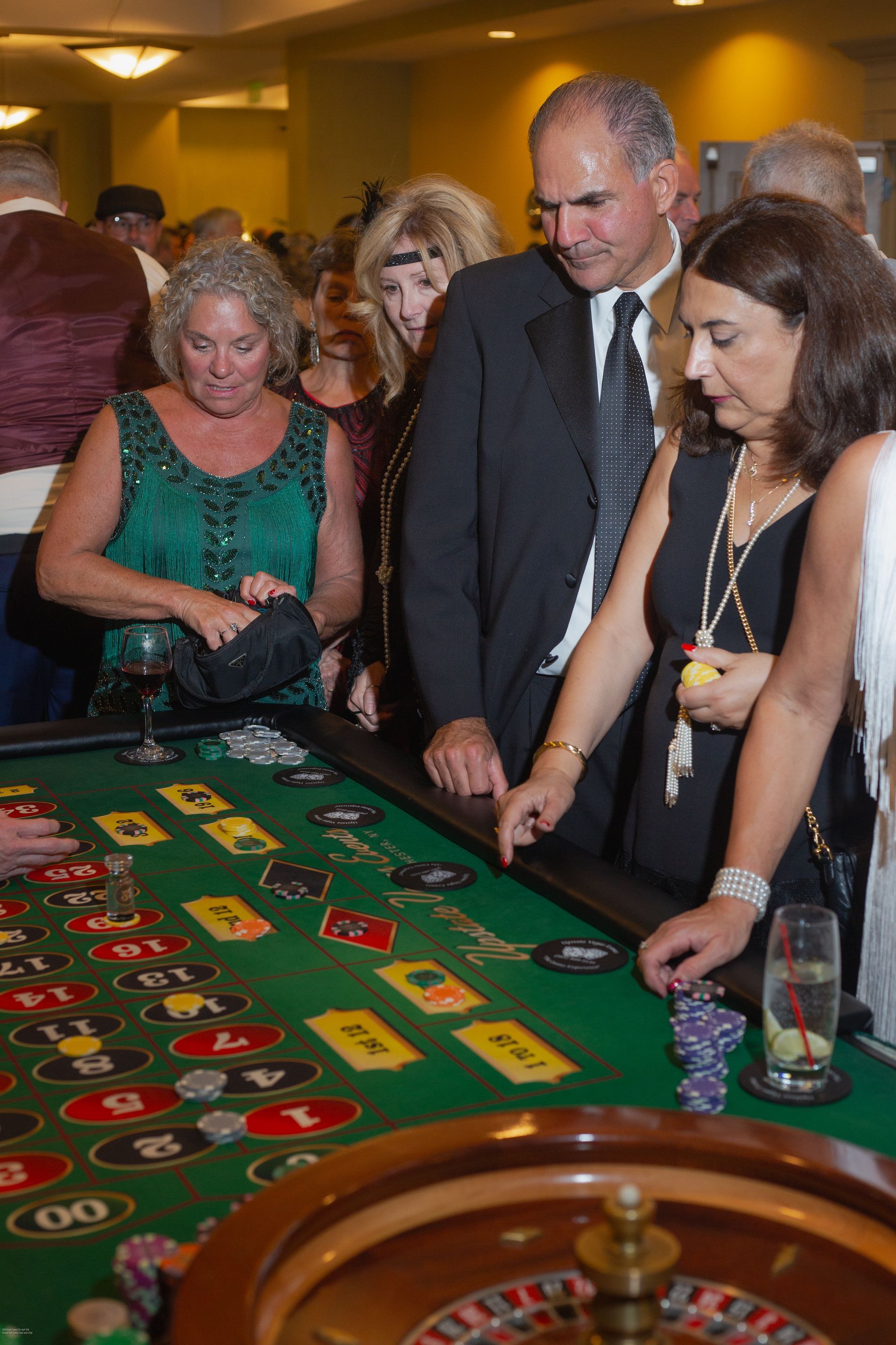 A group of people are playing roulette in a casino.