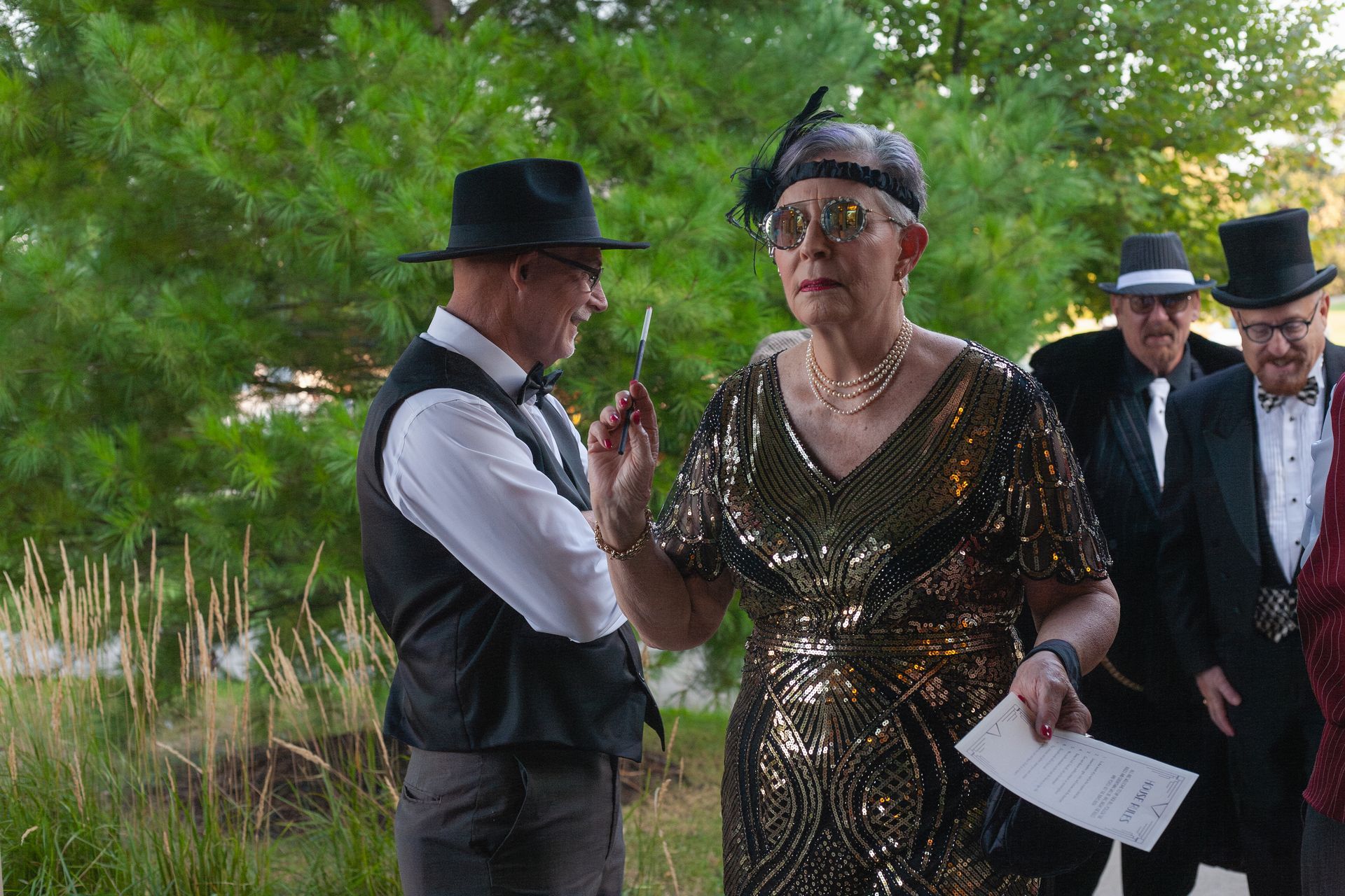 A woman in a dress is standing next to a man in a hat.