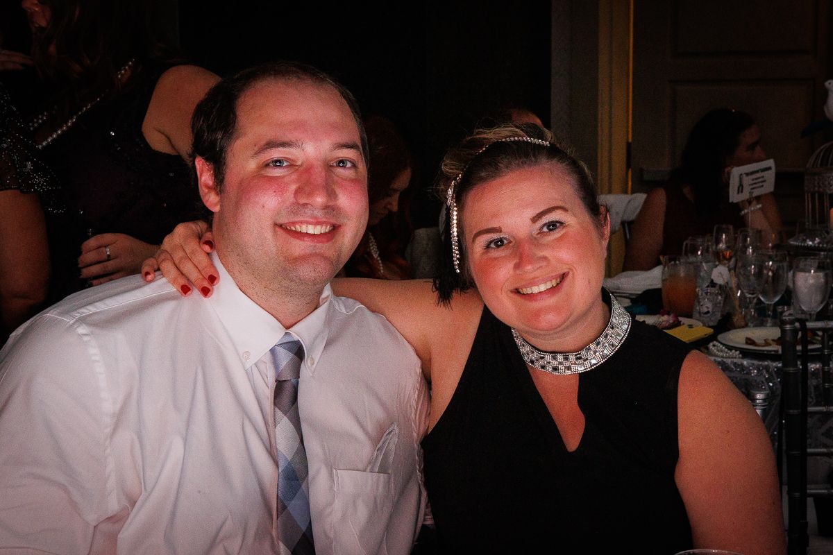A man and a woman are posing for a picture at a party.