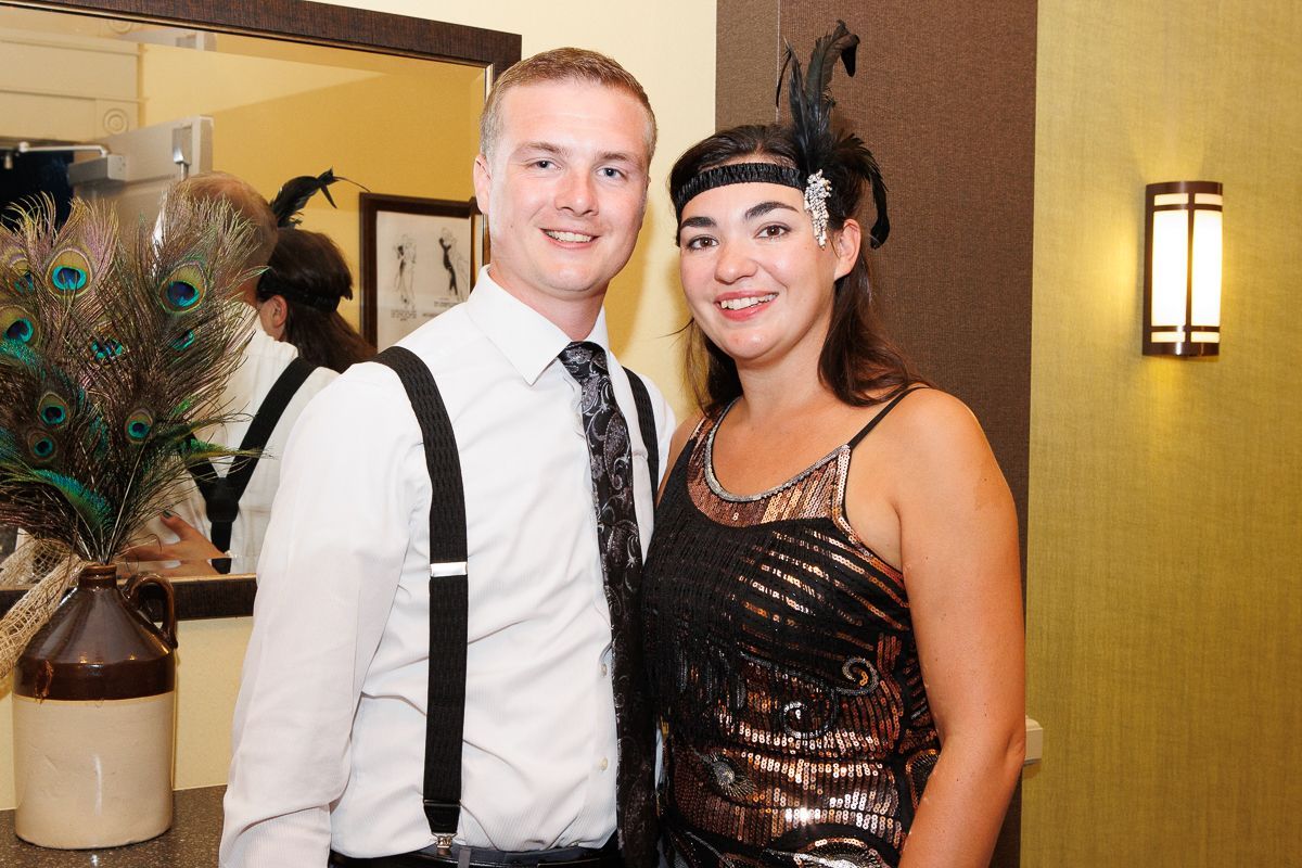 A man and a woman are posing for a picture in front of a mirror.