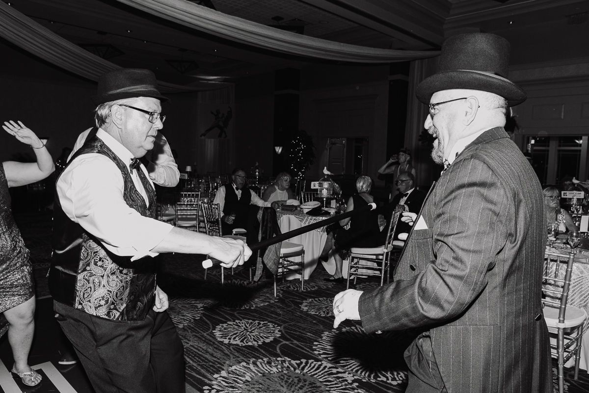 A black and white photo of two men dancing at a party.