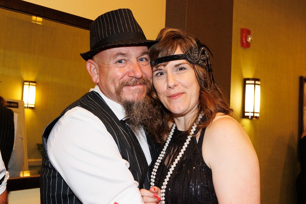 A man and a woman are posing for a picture in a room.