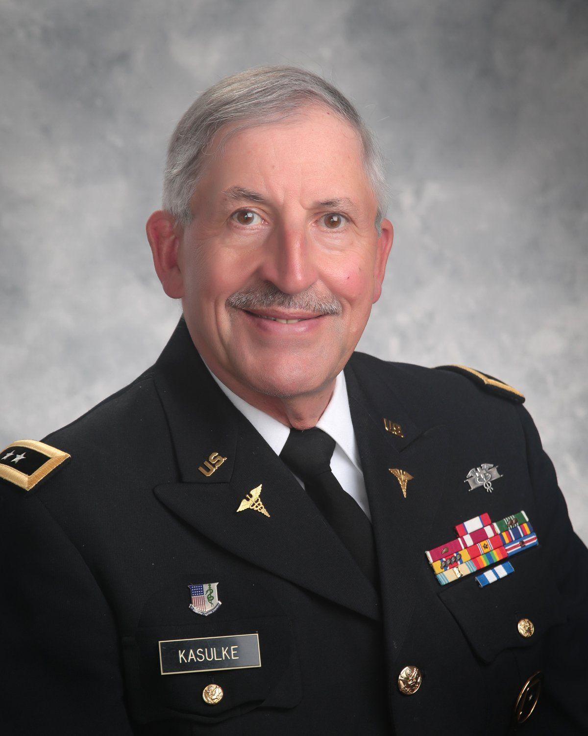 A man in a military uniform has a name tag that says kaspar