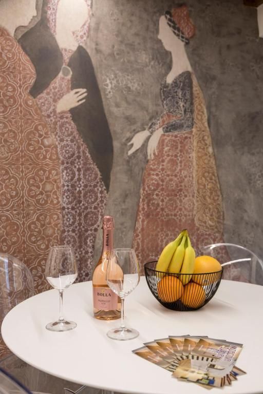 Un tavolo con una ciotola di frutta e una bottiglia di vino
