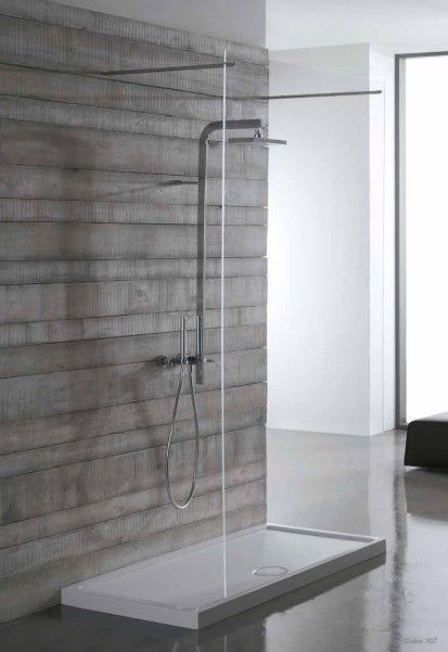 Un bagno con cabina doccia e muro di mattoni