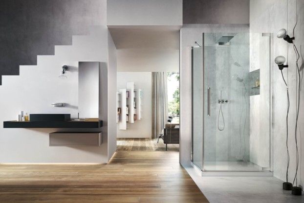 Un bagno con cabina doccia, lavandino, specchio e scale.