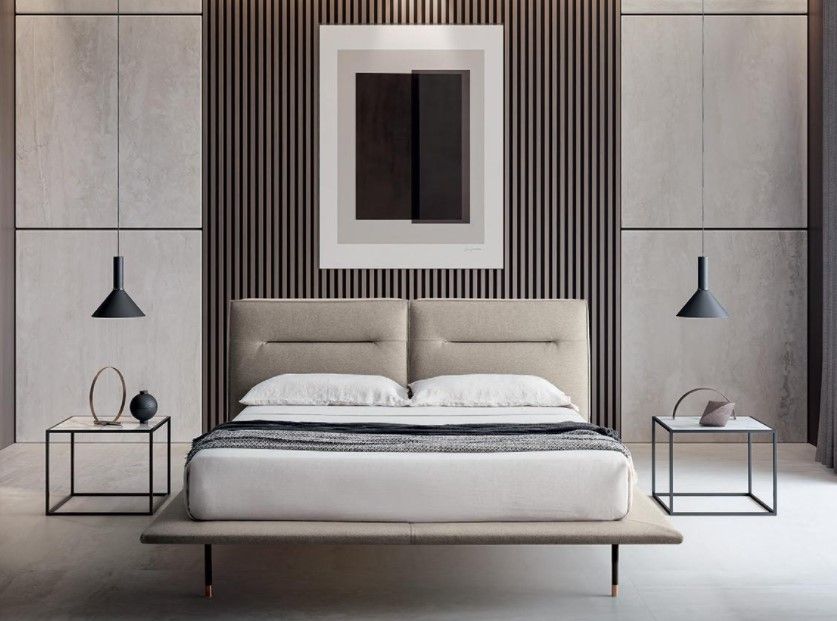 Una camera da letto con un letto, due comodini e un quadro alla parete.