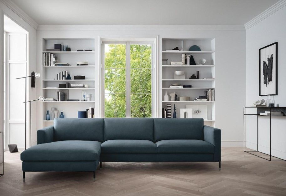 Un soggiorno con un divano componibile blu e scaffali
