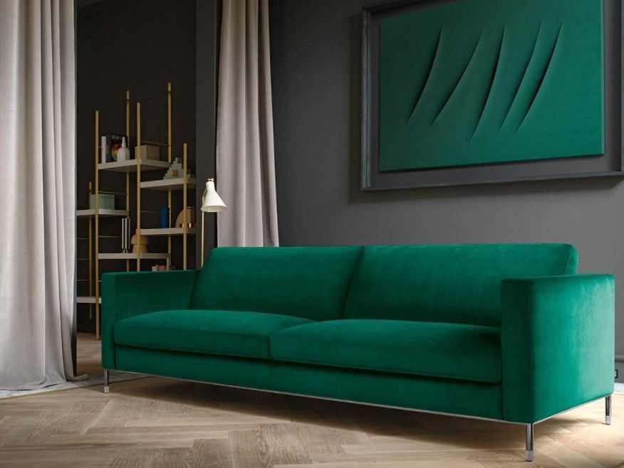 Un divano verde è posizionato nel soggiorno accanto a un quadro sulla parete.