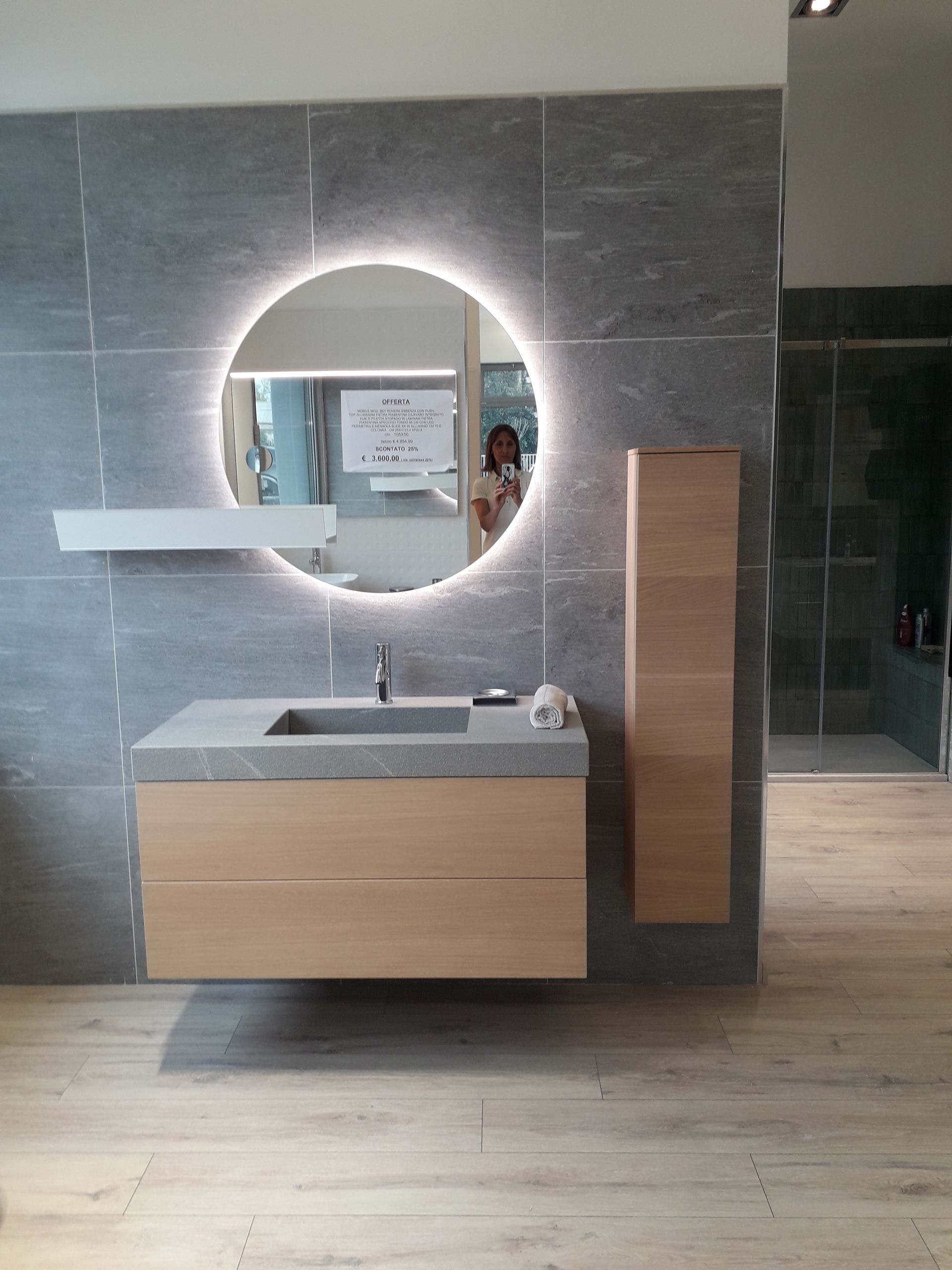 Un bagno con un lavandino e uno specchio rotondo