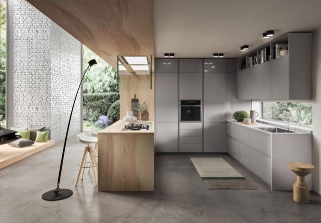 Una cucina moderna con mobili grigi e un'isola in legno.