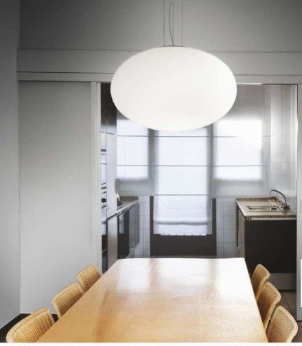 Una sala da pranzo con tavolo e sedie e una luce appesa al soffitto