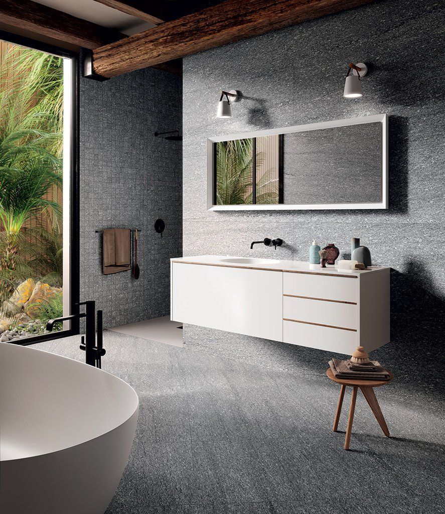 Un bagno con vasca, lavandino e specchio.