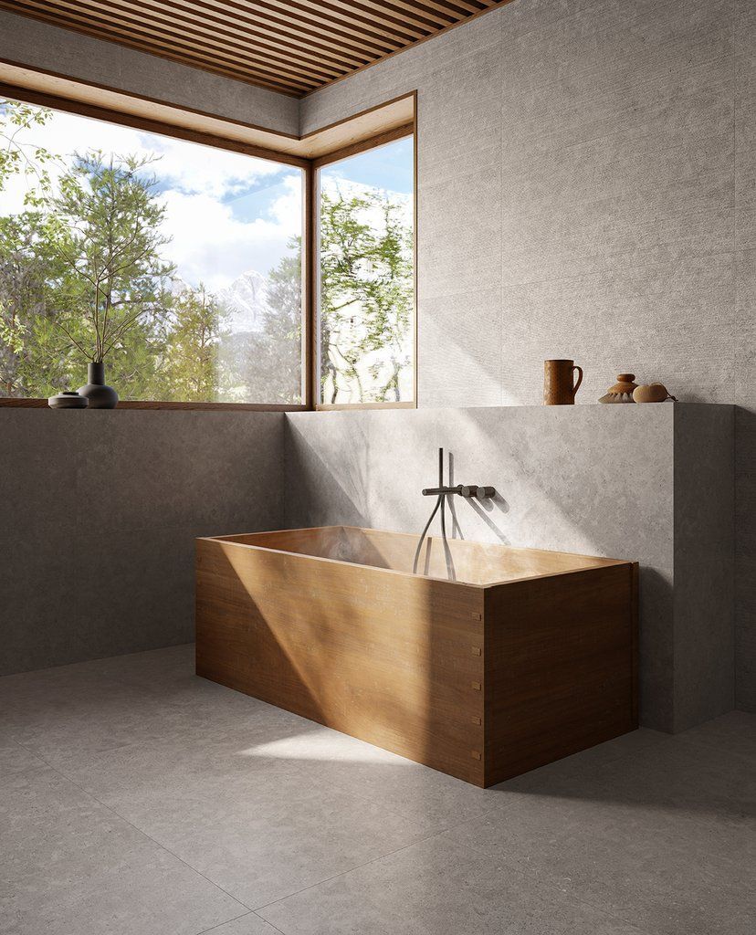 Un bagno con vasca in legno e grande finestra.