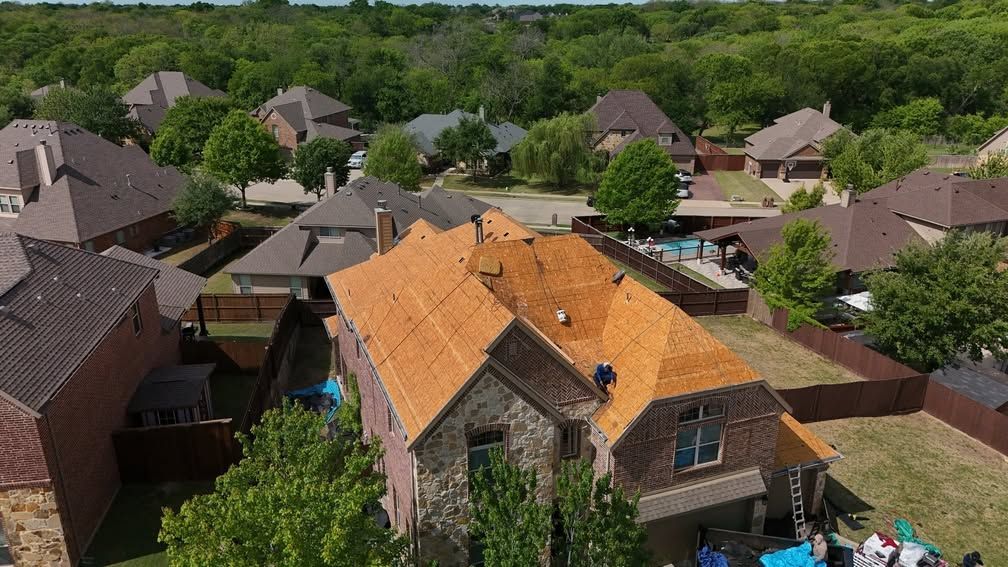 Aerial view of suburban homes with orange roofs and green trees on a sunny day