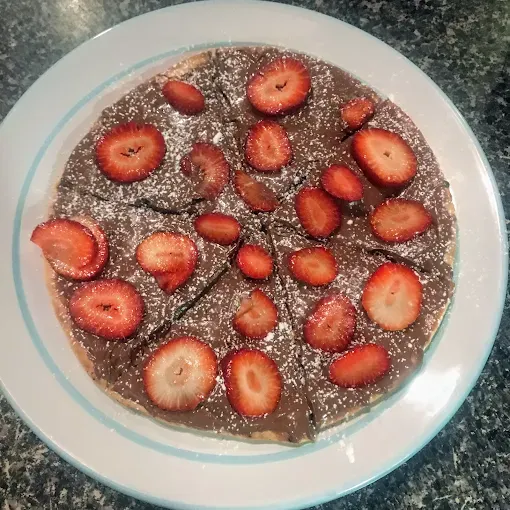 Chocolate Dessert Topped With Sliced Strawberries on a White Plate — Romanas Italian Restaurant in Mermaid Beach, QLD