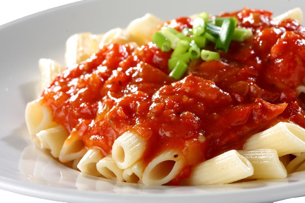 Pasta Topped With Chunky Red Tomato Sauce and Chopped Green Garnish — Romanas Italian Restaurant in Mermaid Beach, QLD