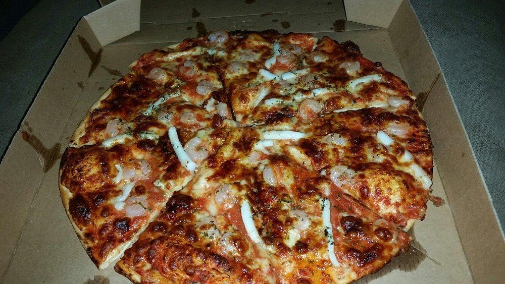 A Pizza is Sitting in a Cardboard Box on a Table — Romanas Italian Restaurant in Mermaid Beach, QLD