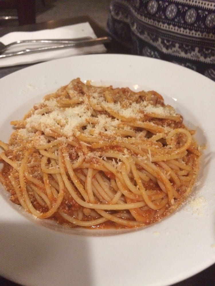 Plate of Spaghetti With Tomato Sauce and Grated Cheese on a White Dish — Romanas Italian Restaurant in Mermaid Beach, QLD