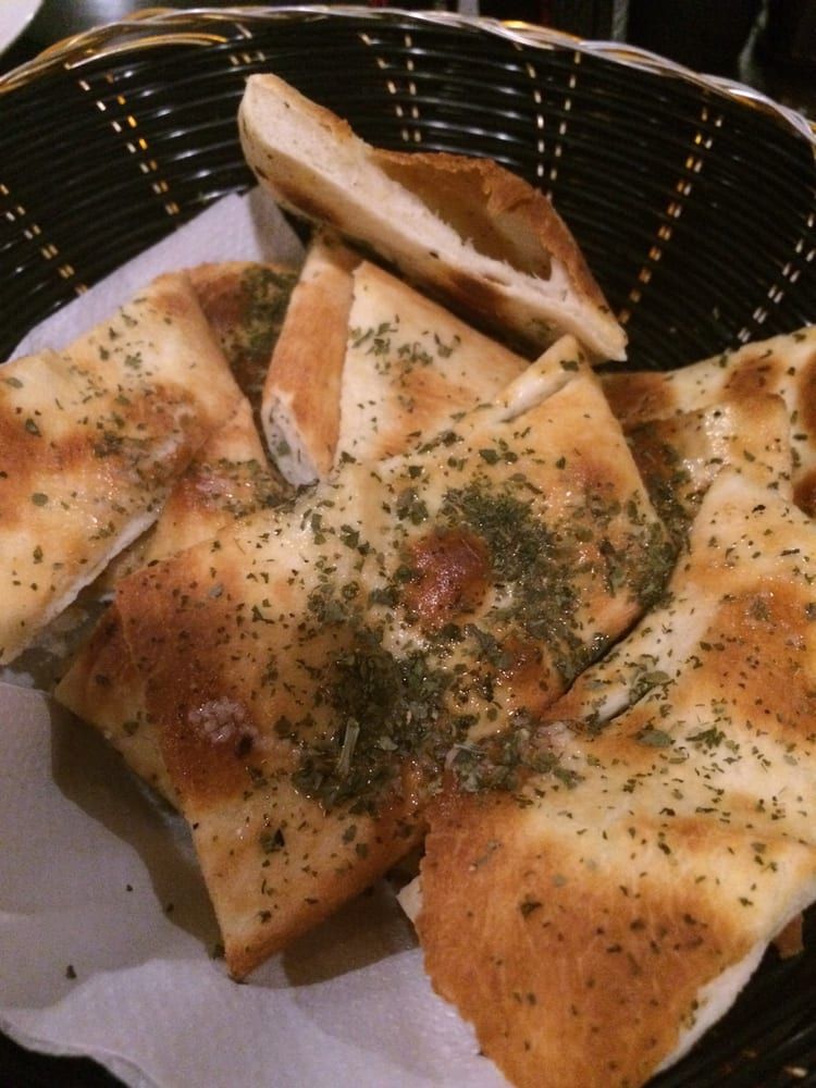 Basket of Herb-topped Flatbread Slices — Romanas Italian Restaurant in Mermaid Beach, QLD