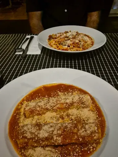Plates of Pasta With Sauce and Grated Cheese on a Tablecloth — Romanas Italian Restaurant in Mermaid Beach, QLD