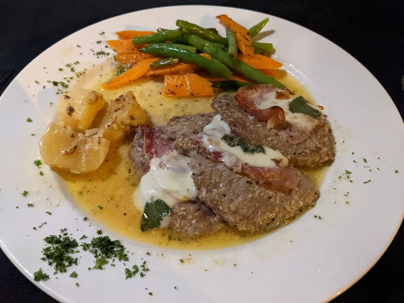 A White Plate Topped With Meat and Vegetables on a Table — Romanas Italian Restaurant in Mermaid Beach, QLD