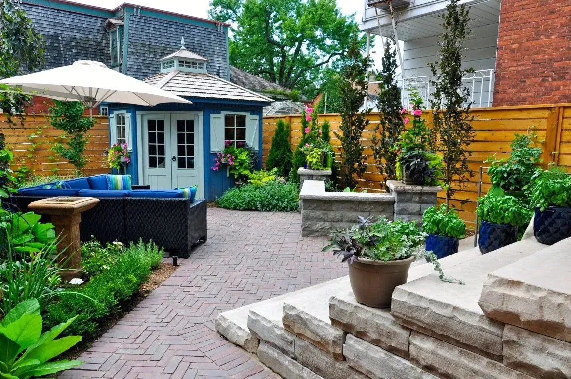 Backyard hardscaping with a stone patio, gazebo, and outdoor seating.