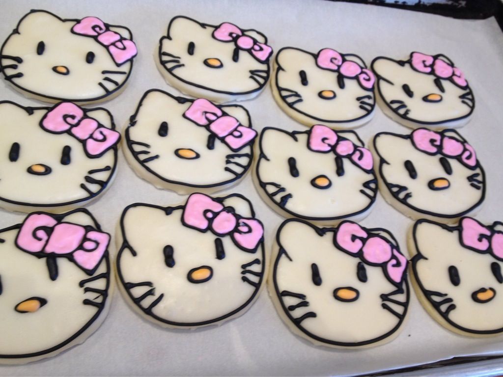 a bunch of hello kitty cookies with pink bows on them