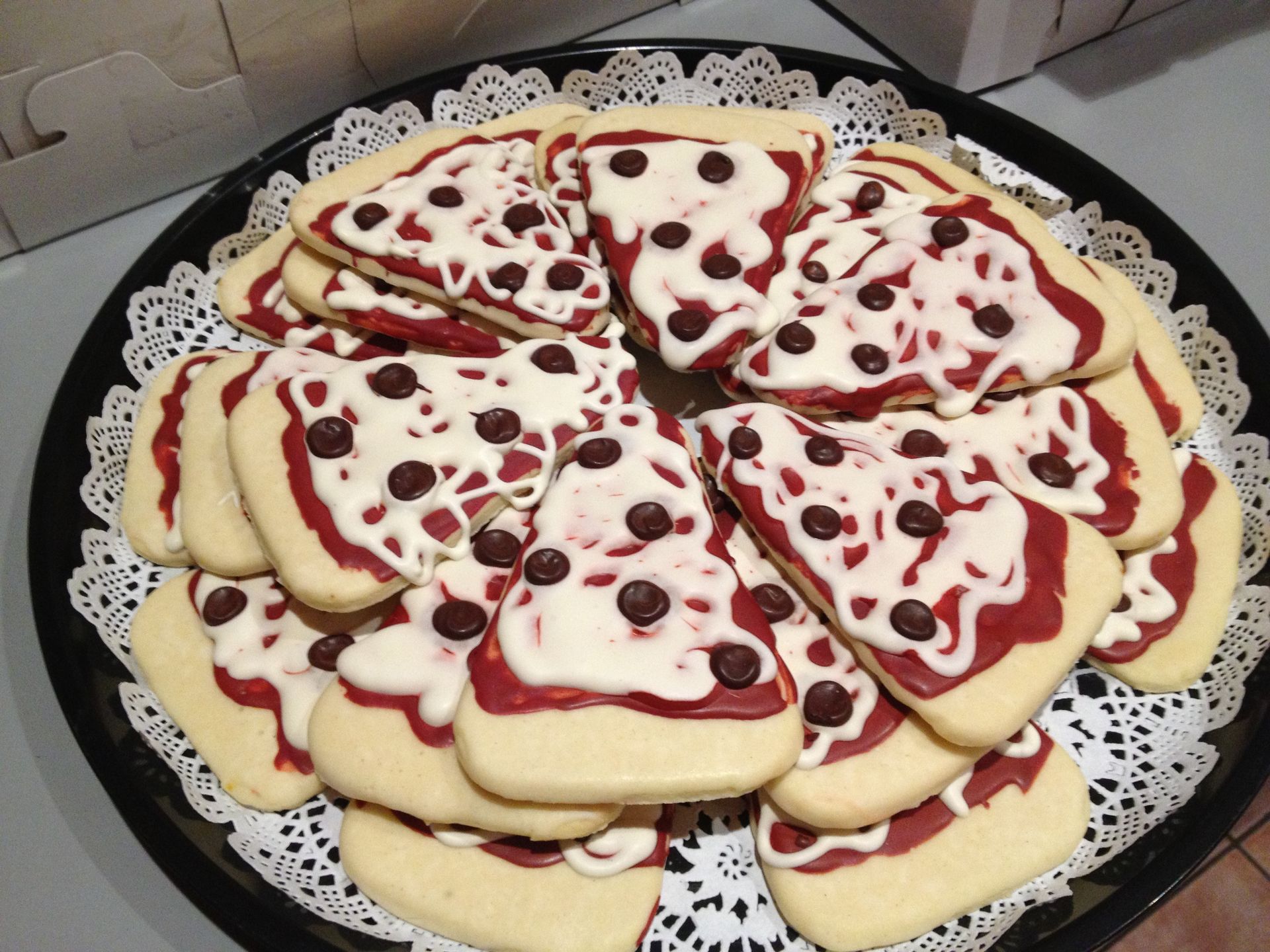 a tray of pizza shaped cookies with chocolate chips on top