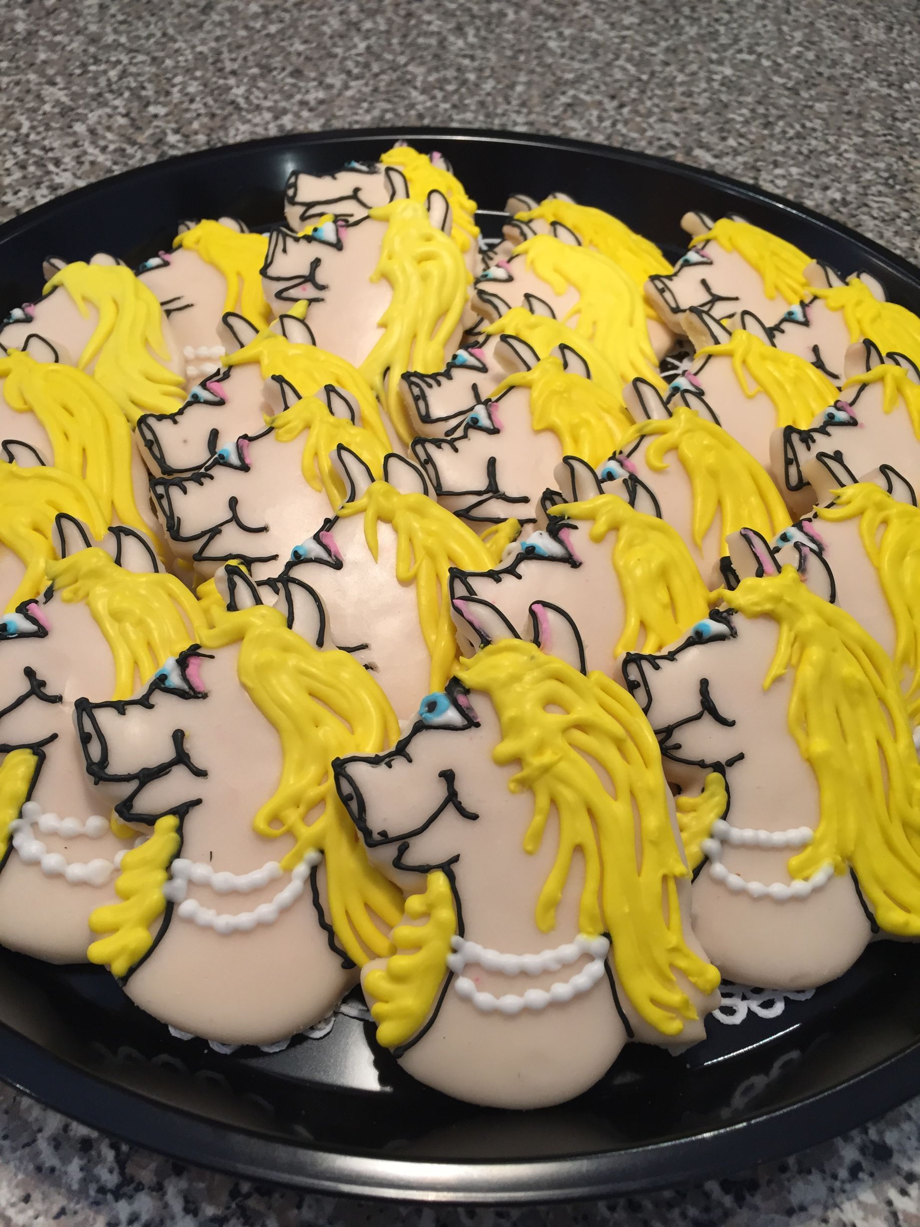 a black plate topped with a bunch of princess cookies