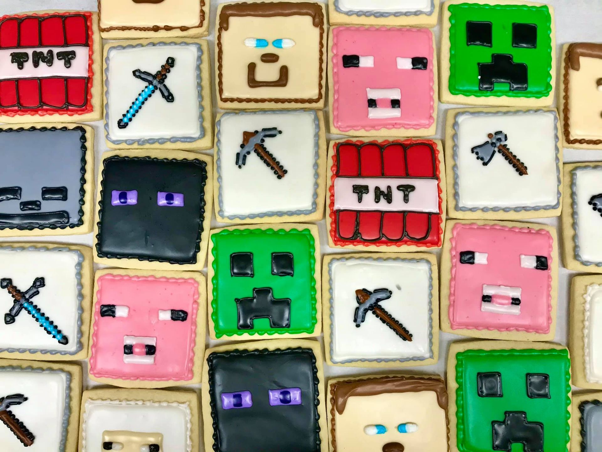 a bunch of minecraft cookies are sitting on top of each other on a table .