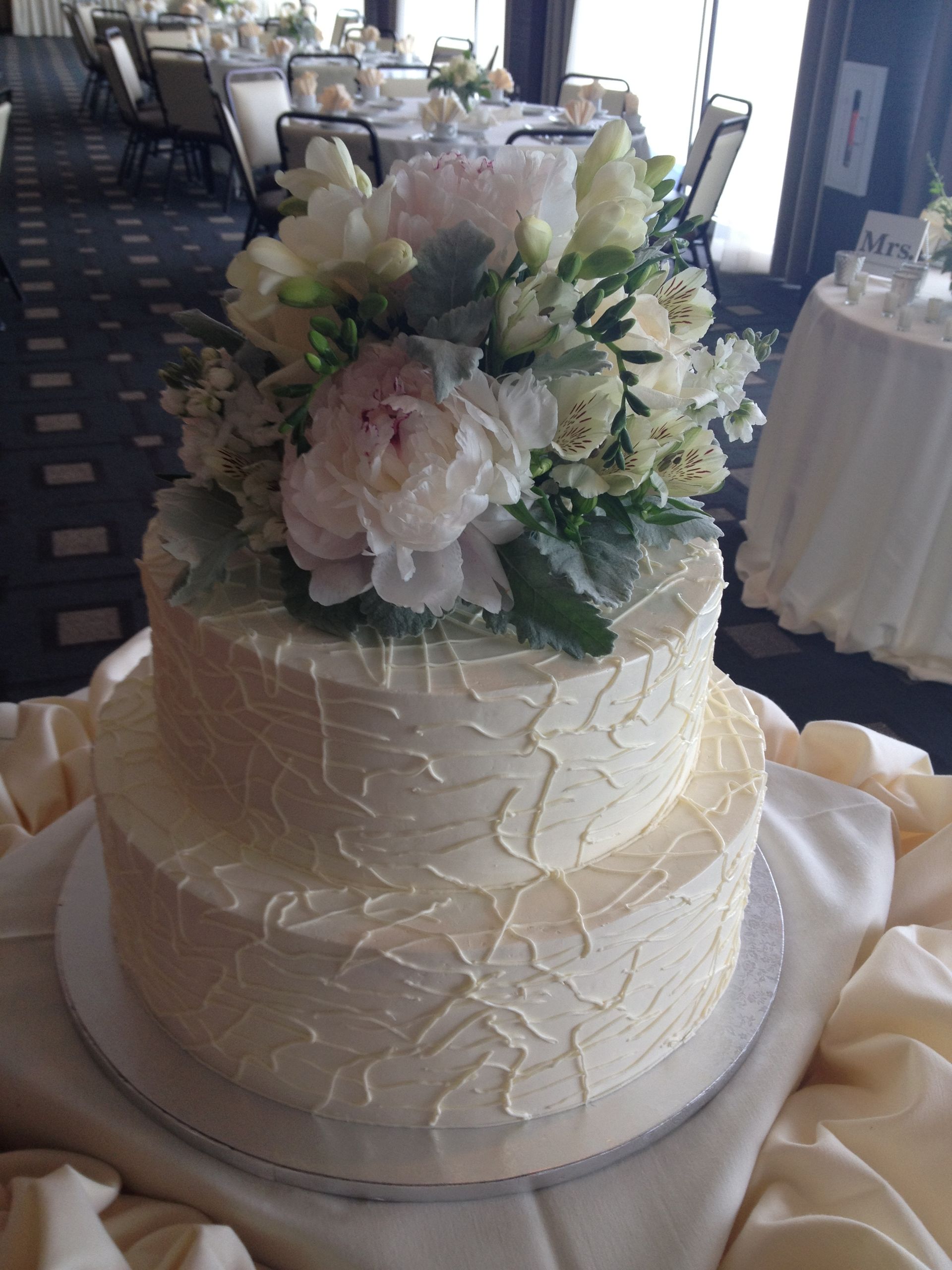 a wedding cake with white frosting and flowers on top