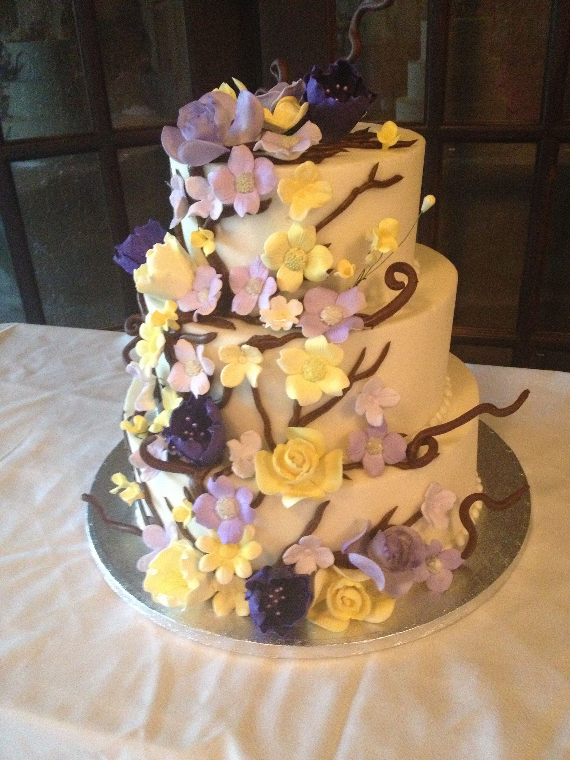 a white cake with yellow and purple flowers on it