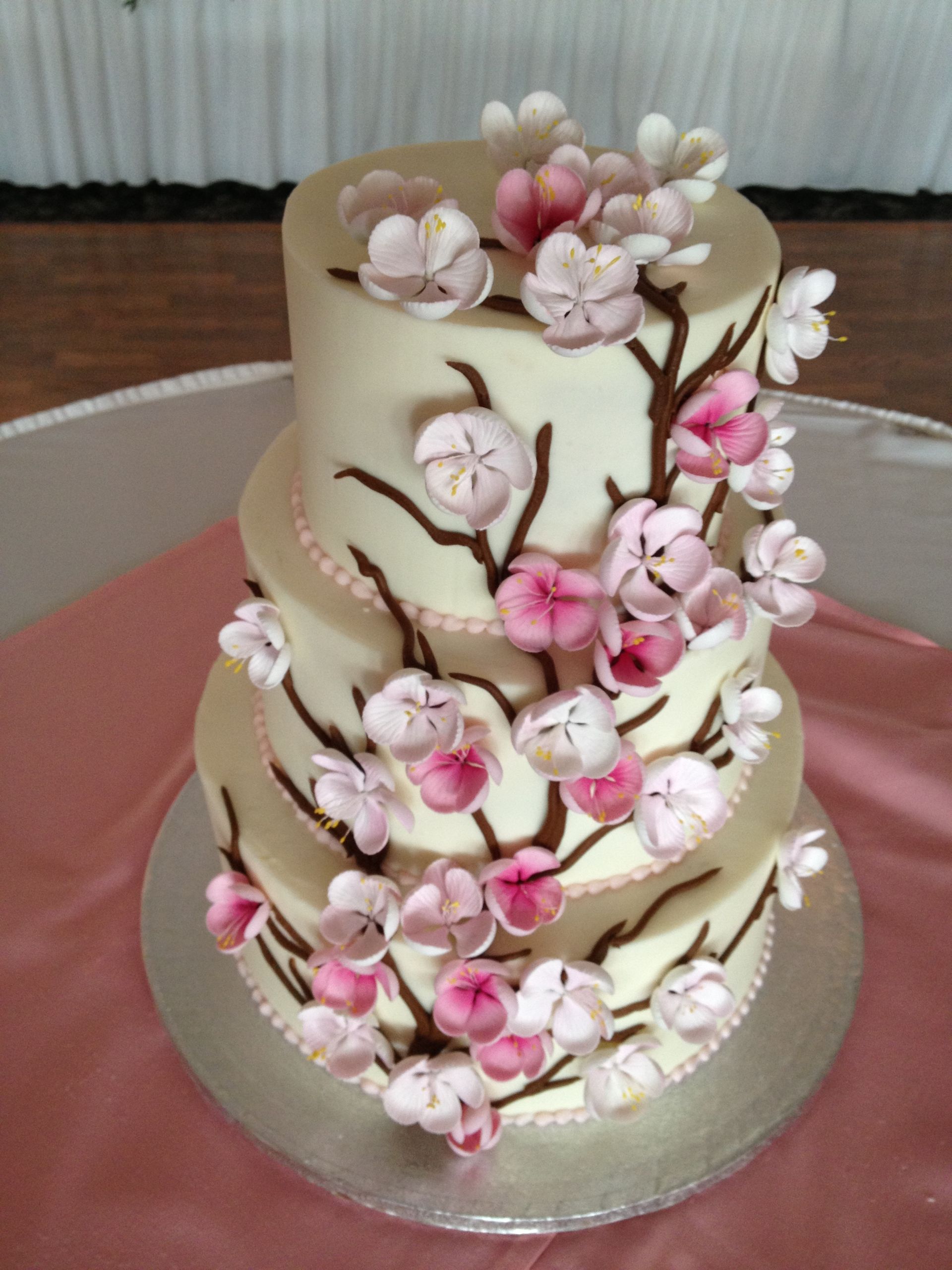 a three tiered cake with pink flowers on it