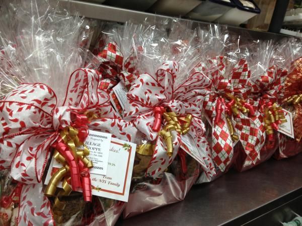 a row of bags of food wrapped in plastic with ribbons and bows on a shelf .