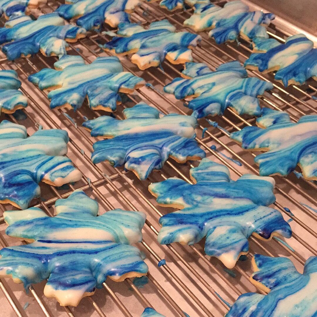 a bunch of blue and white cookies on a cooling rack