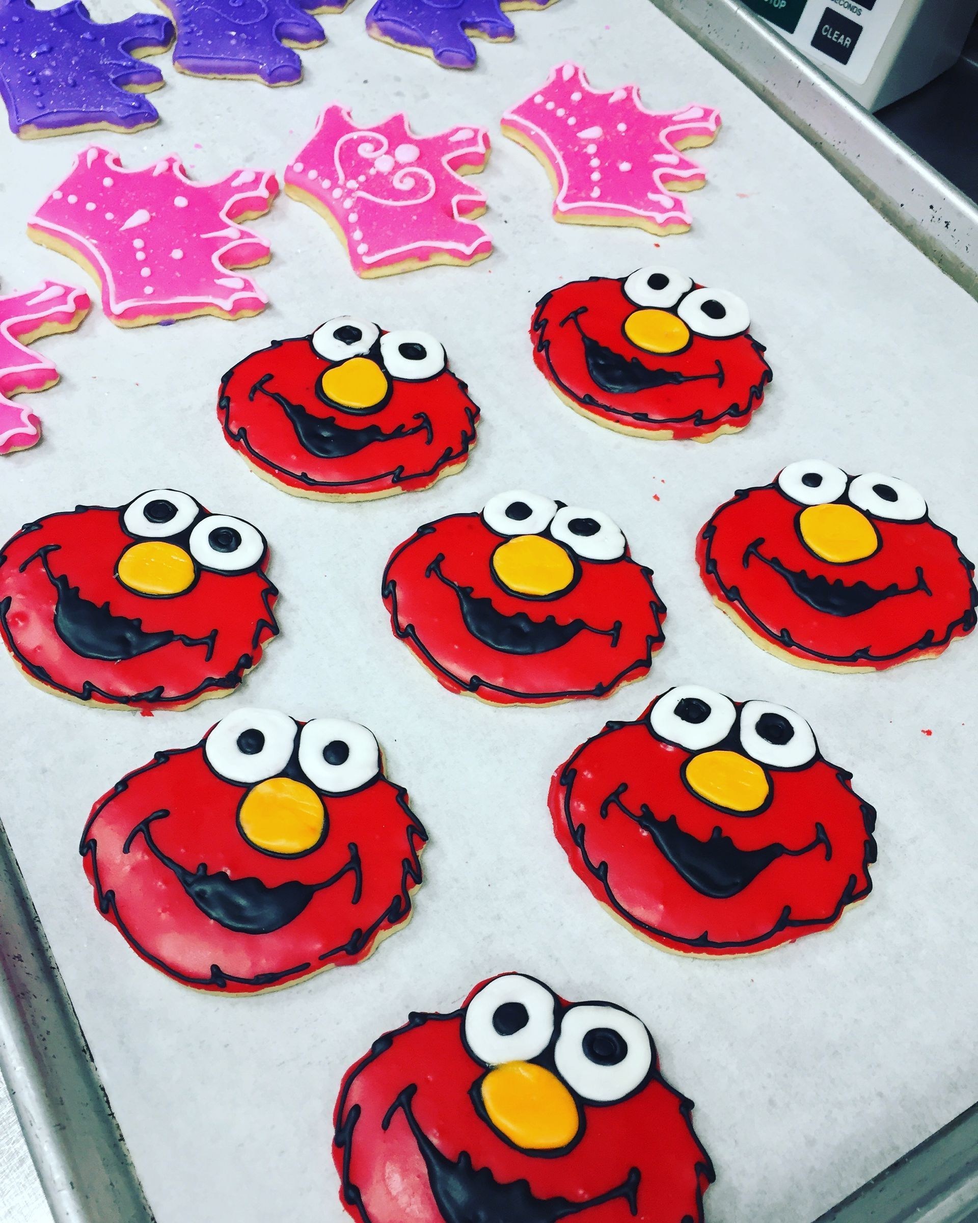 a tray of sesame street cookies with elmo faces on them