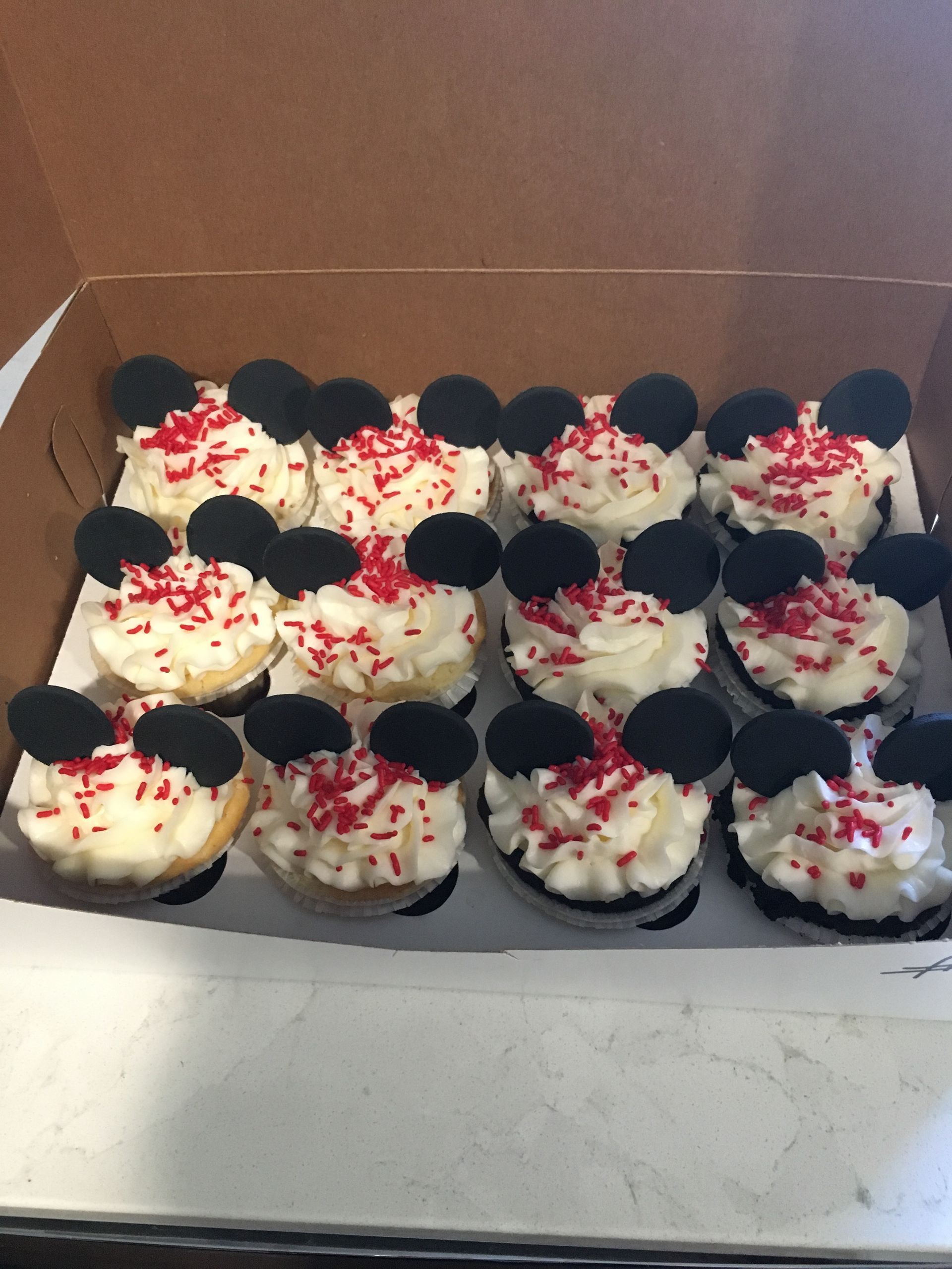 a box of mickey mouse cupcakes with red sprinkles