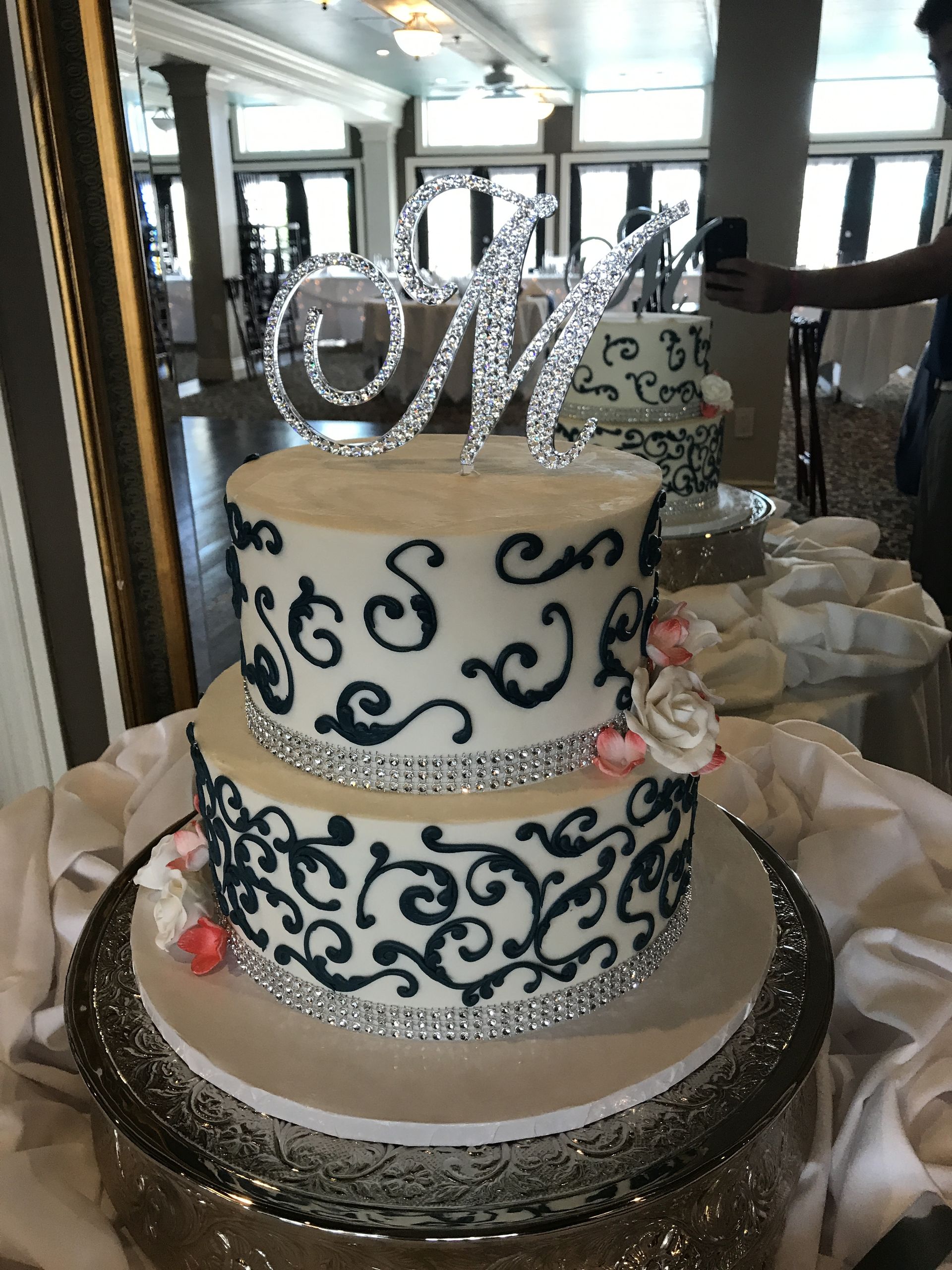 a wedding cake with the letter m on top of it