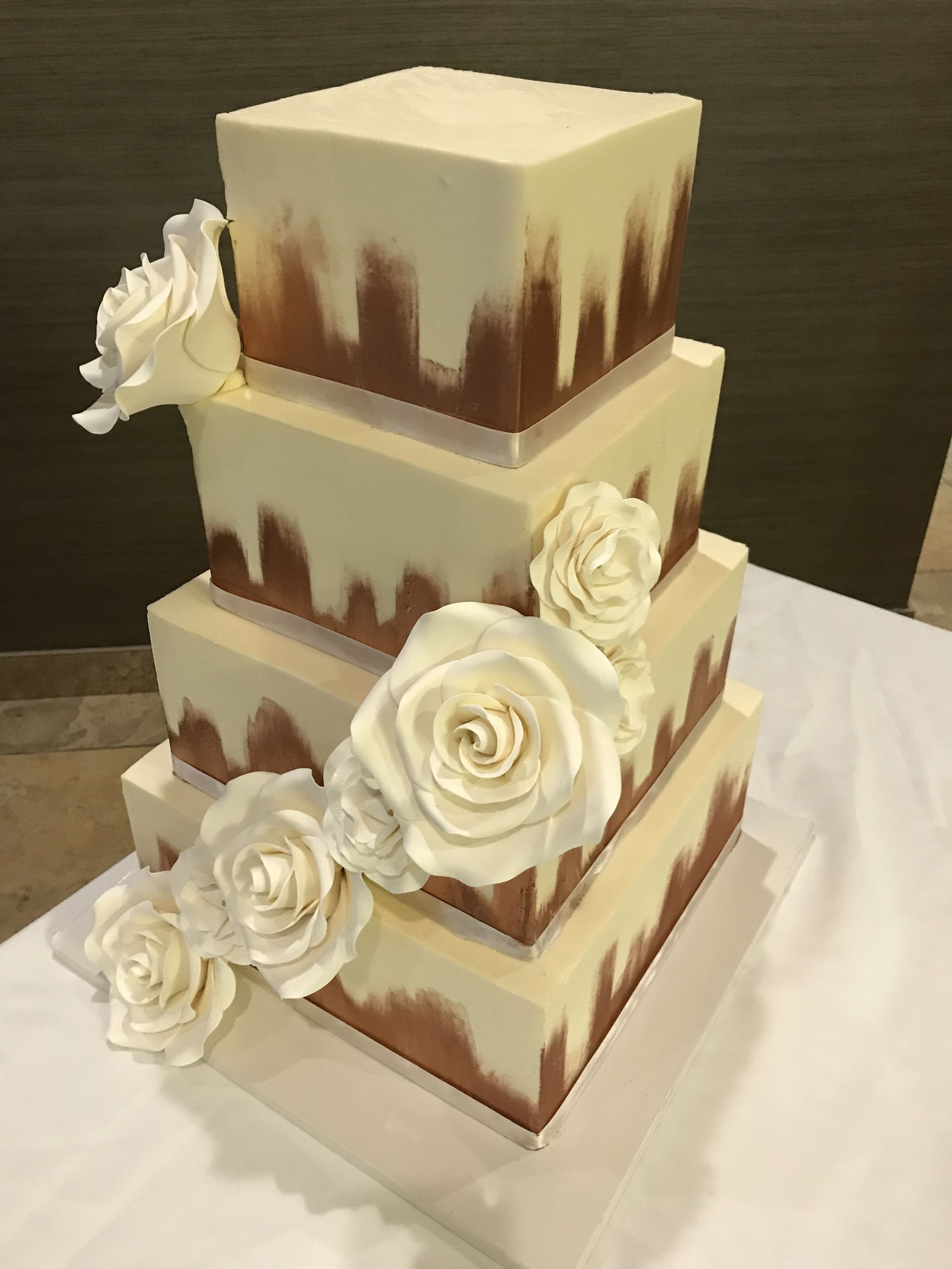 a wedding cake with white roses on it is sitting on a table .