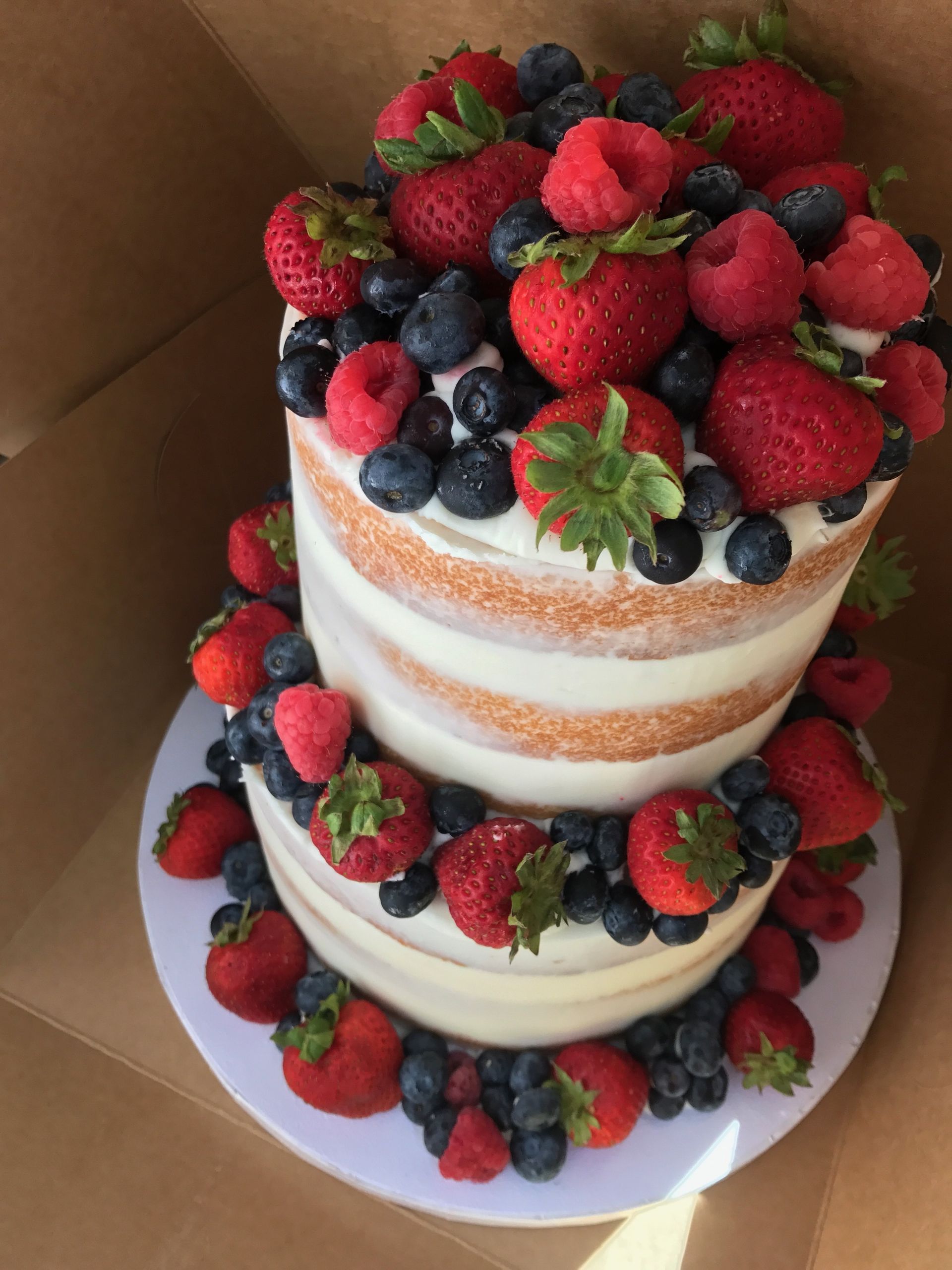 a cake with strawberries blueberries and raspberries on top